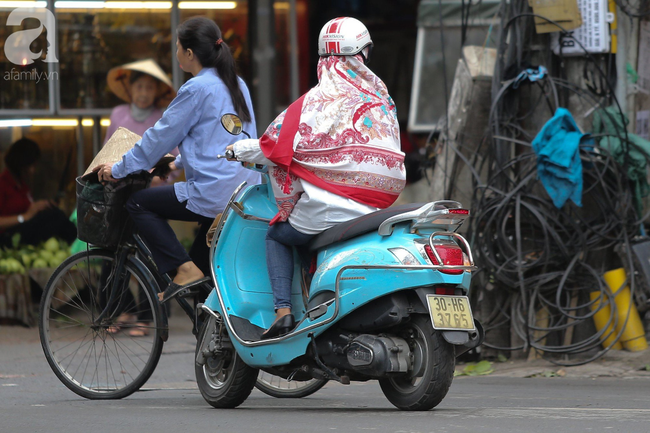 Hà Nội: Không khí lạnh tràn về, nhiệt độ giảm mạnh, người dân co ro, mặc áo ấm khi ra đường - Ảnh 10.