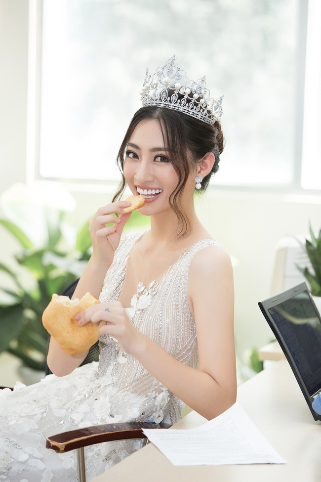 Hoa hậu Lương Thùy Linh đầu đội vương miện, tay bóc bánh ăn vội mà vẫn đáng yêu lạ thường  - Ảnh 3.