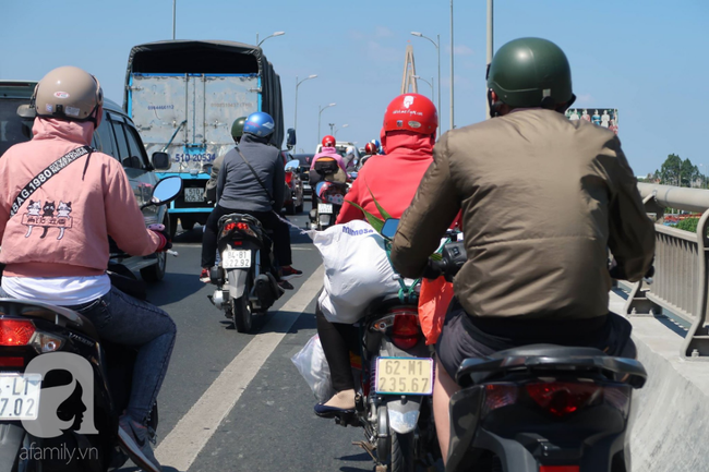 Hàng nghìn người miền Tây đổ lên Sài Gòn chiều tối mùng 6 Tết, mang cả theo gà, chó khiến quốc lộ 1 kẹt cứng - Ảnh 12.