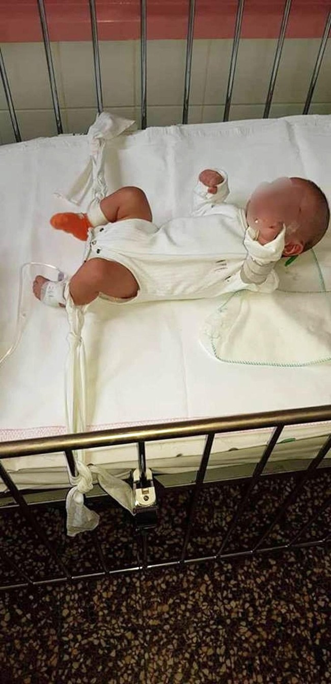 Bức hình cặp song sinh 5 tháng tuổi bị trói chặt trên giường bệnh và sự thật gây sốc khiến ai cũng phẫn nộ - Ảnh 2.