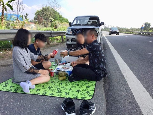Hình ảnh gây phẫn nộ: Cả gia đình trải bạt, ăn uống trên cao tốc Nội Bài - Lào Cai bất chấp dòng phương  - Ảnh 1.