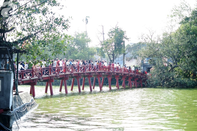 Nắng đẹp, người Hà Nội rủ nhau xuống phố du xuân, xúng xính áo dài chụp ảnh đầu năm mới - Ảnh 2.