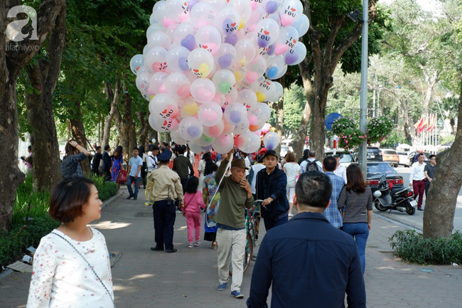 Nắng đẹp, người Hà Nội rủ nhau xuống phố du xuân, xúng xính áo dài chụp ảnh đầu năm mới - Ảnh 1.