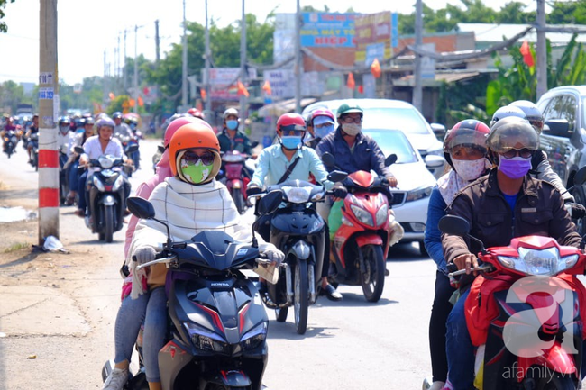 Bình Dương: Bố mẹ ẵm con, tay xách nách mang trở lại thành phố làm việc giữa trời nắng gắt, trẻ con ngủ gục trên xe - Ảnh 1.