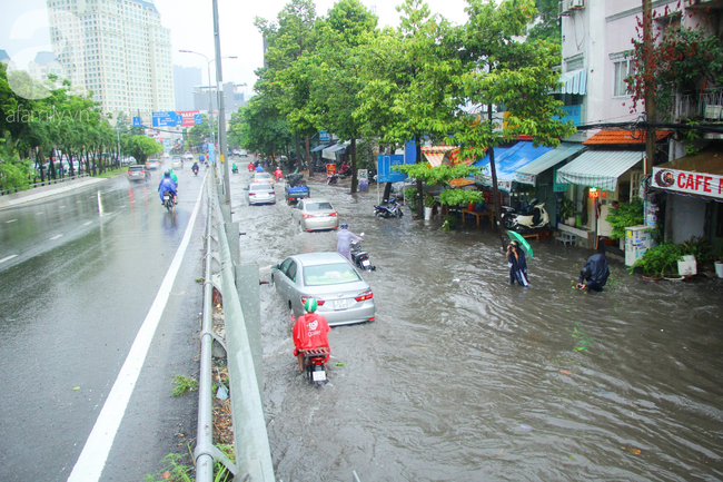 Mưa lớn kéo dài hơn 30 phút, người Sài Gòn bì bõm lội nước, té ngã vì nhiều tuyến đường ngập nặng - Ảnh 13.