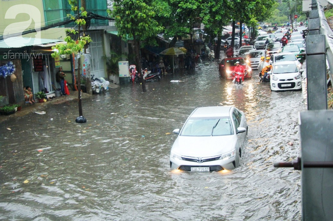 Mưa lớn kéo dài hơn 30 phút, người Sài Gòn bì bõm lội nước, té ngã vì nhiều tuyến đường ngập nặng - Ảnh 14.