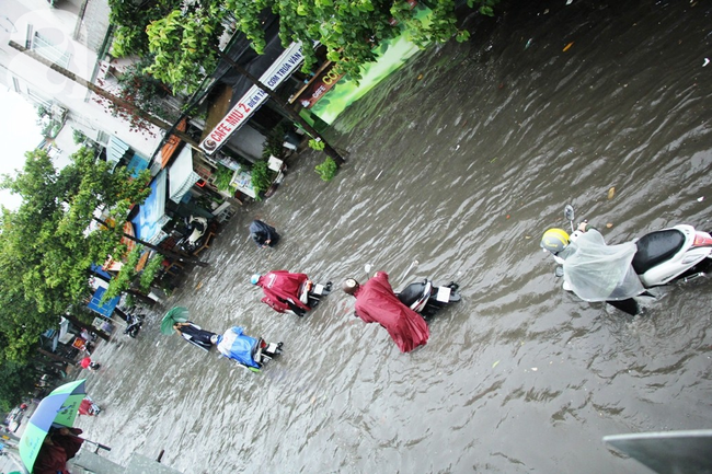 Mưa lớn kéo dài hơn 30 phút, người Sài Gòn bì bõm lội nước, té ngã vì nhiều tuyến đường ngập nặng - Ảnh 17.