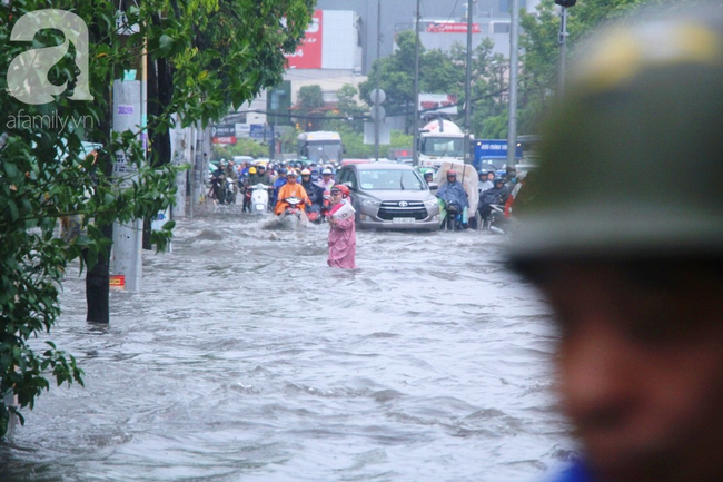 Mưa lớn kéo dài hơn 30 phút, người Sài Gòn bì bõm lội nước, té ngã vì nhiều tuyến đường ngập nặng - Ảnh 19.
