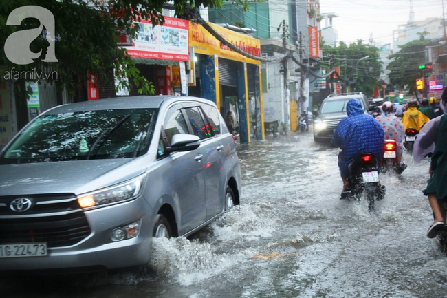 Mưa lớn kéo dài hơn 30 phút, người Sài Gòn bì bõm lội nước, té ngã vì nhiều tuyến đường ngập nặng - Ảnh 20.