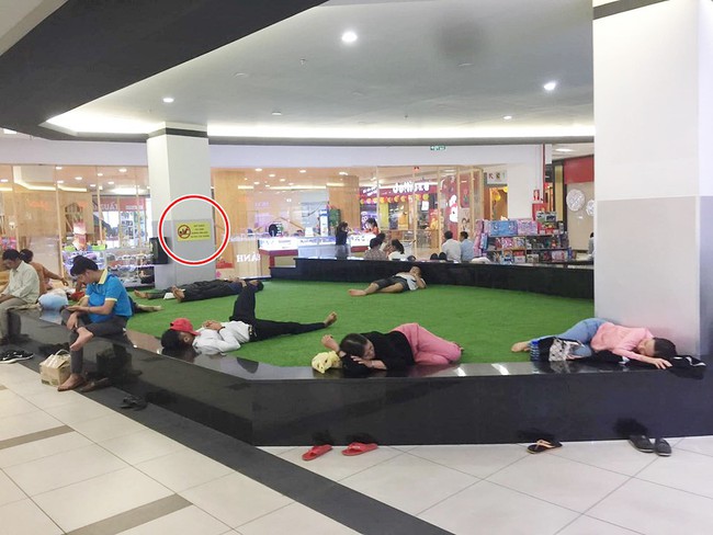 Hình ảnh hội phụ huynh ké điều hòa nằm ngủ giữa trung tâm thương mại, bất chấp biển cấm khiến dân tình ngao ngán - Ảnh 1.