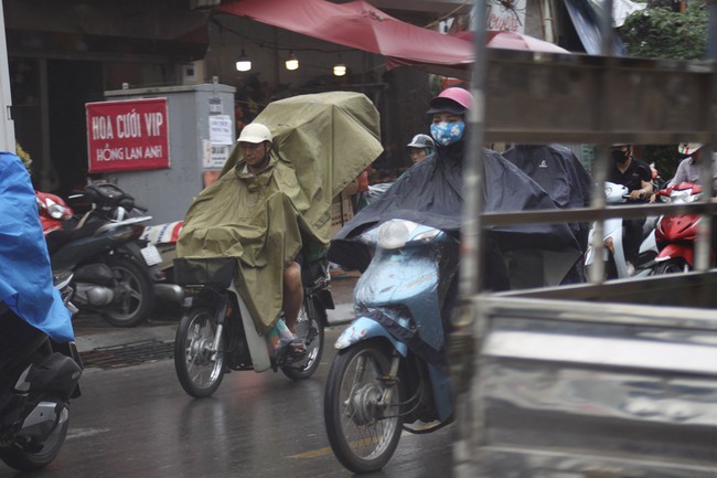 Ch&ugrave;m ảnh: H&agrave; Nội chớm lạnh, buổi s&aacute;ng người d&acirc;n mặc &aacute;o kho&aacute;c, đội mưa đi l&agrave;m - Ảnh 1.