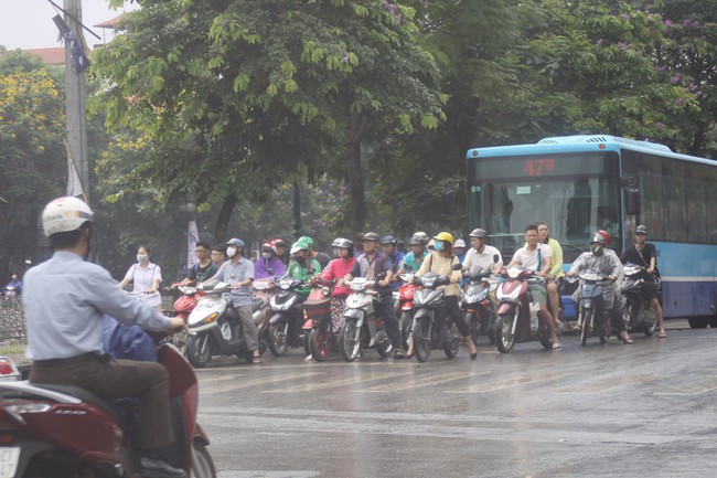 Ch&ugrave;m ảnh: H&agrave; Nội chớm lạnh, buổi s&aacute;ng người d&acirc;n mặc &aacute;o kho&aacute;c, đội mưa đi l&agrave;m - Ảnh 2.