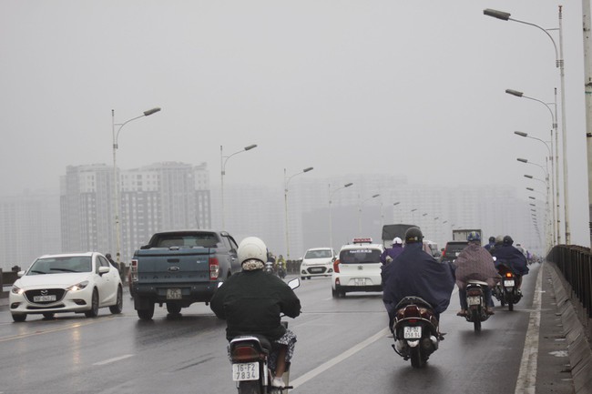 Ch&ugrave;m ảnh: H&agrave; Nội chớm lạnh, buổi s&aacute;ng người d&acirc;n mặc &aacute;o kho&aacute;c, đội mưa đi l&agrave;m - Ảnh 3.