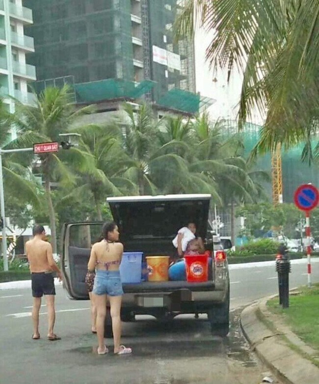 Cả gia đình dừng đỗ xe dù có biển cấm để... tắm giữa đường ở Đà Nẵng - Ảnh 1.