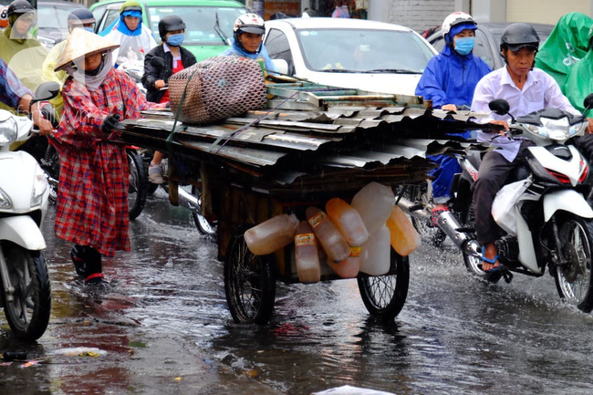 Nước ngập đến bàn thờ ông thần Tài sau mưa lớn ở TP.HCM: Người bì bõm tát nước, người bán buôn ế ẩm - Ảnh 11.