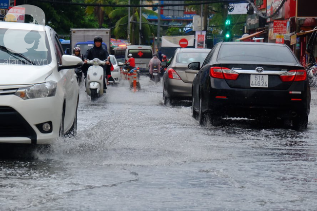 Nước ngập đến bàn thờ ông thần Tài sau mưa lớn ở TP.HCM: Người bì bõm tát nước, người bán buôn ế ẩm - Ảnh 1.