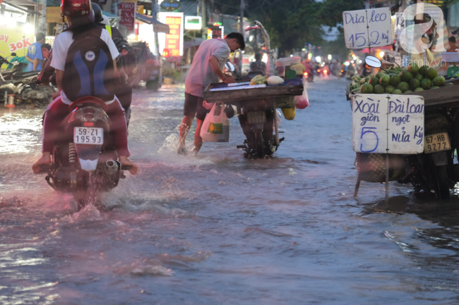 TP.HCM: Ngập lênh láng từ đường vào nhà, người dân bán buôn ế ẩm, khốn khổ dùng đủ mọi cách ngăn nước - Ảnh 12.