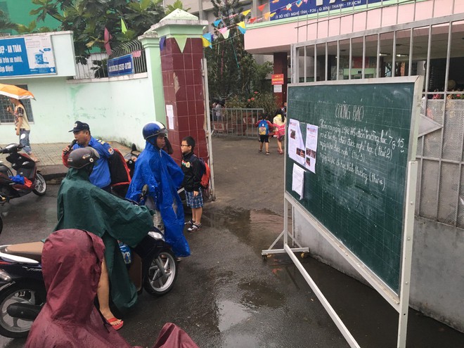 Ảnh hưởng của bão Tembin, người Sài Gòn chật vật đi làm trong mưa, nhiều học sinh đến trường mới biết được nghỉ học - Ảnh 11.