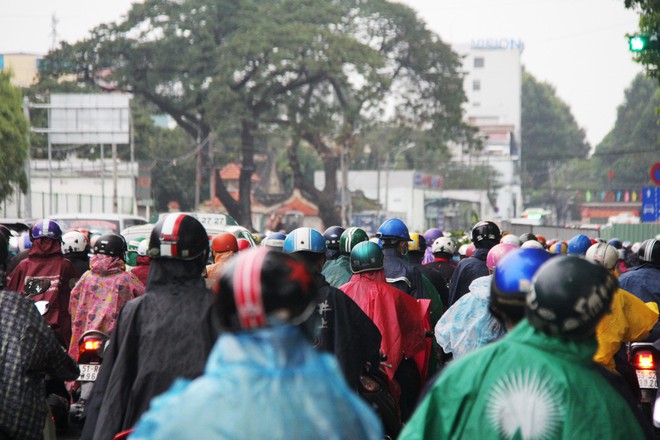Ảnh hưởng của bão Tembin, người Sài Gòn chật vật đi làm trong mưa, nhiều học sinh đến trường mới biết được nghỉ học - Ảnh 2.