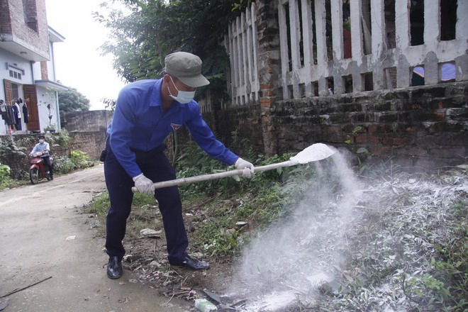 Hà Nội: 10 ngày sau lũ, người dân Tân Tiến rắc vôi bột trắng đường phòng bệnh dịch - Ảnh 13.