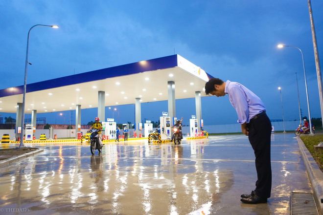 Hà Nội: Hình ảnh Tổng giám đốc cây xăng Nhật cúi chào, điều hướng phương tiện mua xăng nhiều giờ dưới mưa gây bão mạng - Ảnh 1.