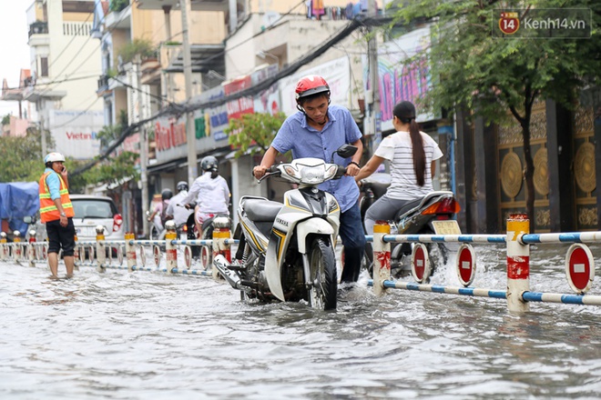 Sài Gòn ngập cả buổi sáng sau trận mưa đêm, nhân viên thoát nước ra đường đẩy xe chết máy giúp người dân - Ảnh 1.