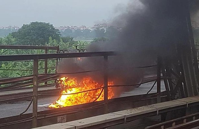 Người phụ nữ hoảng loạn nhảy khỏi xe máy đang bốc cháy trên cầu Long Biên - Ảnh 1.