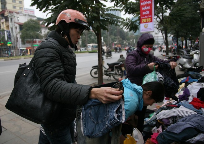 Nhiều người nghèo vui mừng khi kiếm được bộ quần áo miễn phí để diện Tết trên phố Hà Nội - Ảnh 1.