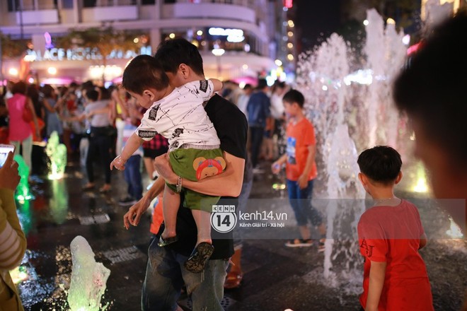 Sài Gòn tối mùng 1 Tết: Trẻ em thích thú cởi áo, nhảy vào đài phun nước đường hoa Nguyễn Huệ để nô đùa - Ảnh 13.