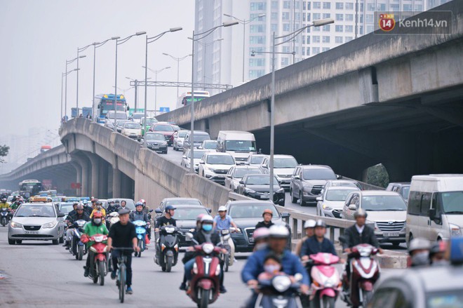 Người dân mang theo hành lí chất trên nóc ô tô, xe máy đổ về Hà Nội và Sài Gòn sau kì nghỉ Tết Nguyên đán kéo dài 1 tuần - Ảnh 1.