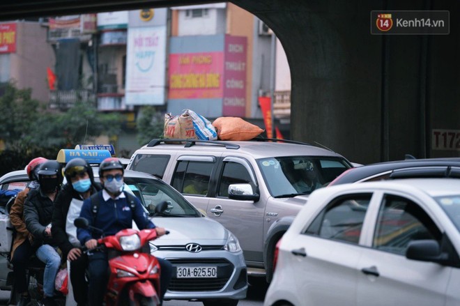 Người dân mang theo hành lí chất trên nóc ô tô, xe máy đổ về Hà Nội và Sài Gòn sau kì nghỉ Tết Nguyên đán kéo dài 1 tuần - Ảnh 5.