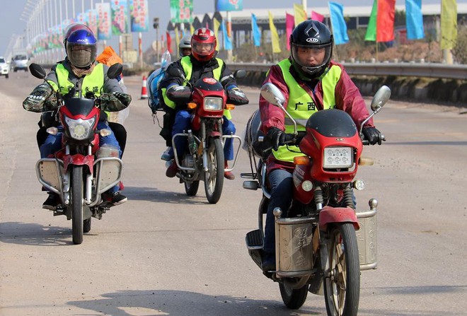 Bố buộc con sau xe máy cùng đống hành lý ngổn ngang, cùng dòng người vượt 500km về quê ăn Tết - Ảnh 1.