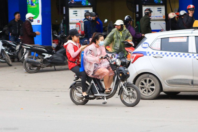 Hà Nội chuyển rét đậm, cha mẹ khoác áo mưa đón con trẻ từ trường về nhà dù trời tạnh ráo - Ảnh 9.