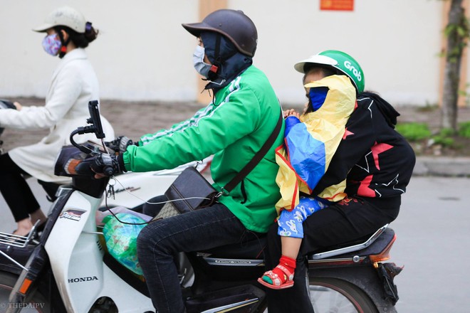 Hà Nội chuyển rét đậm, cha mẹ khoác áo mưa đón con trẻ từ trường về nhà dù trời tạnh ráo - Ảnh 10.