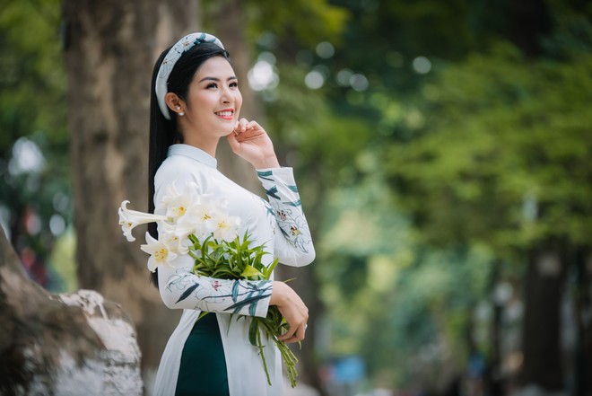 Hoa hậu Mỹ Linh, Ngọc Hân đẹp mê mẩn với hoa loa kèn trên phố - Ảnh 1.