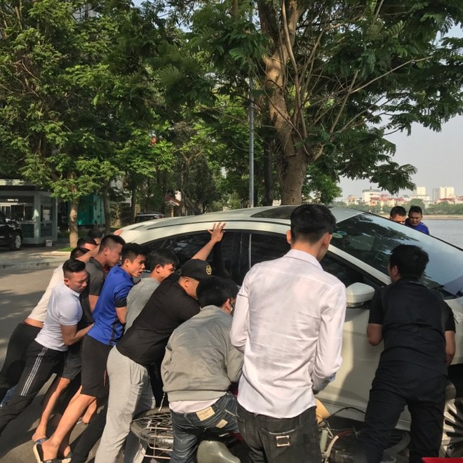 Hà Nội: Hàng chục thanh niên khiêng xe cứu người phụ nữ sau cú mất lái lao lên vỉa hè - Ảnh 1.