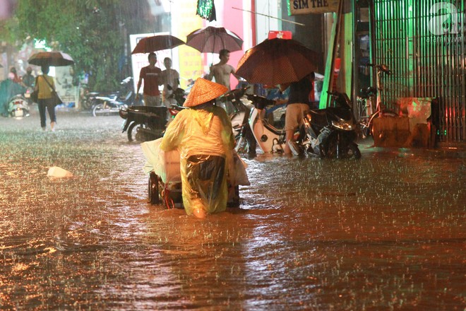 Đường Hà Nội ngập sâu, nhiều người ngã nhào trong mưa lớn - Ảnh 9.