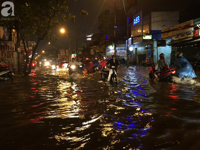 Sài Gòn mưa lớn giờ tan tầm, đường phố lại biến thành sông khiến người dân bì bõm lội nước về nhà - Ảnh 1.