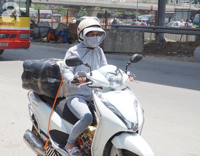 Hà Nội trải qua ngày nắng nóng gắt nhất từ đầu mùa, người dân bịt kín mít khi ra đường - Ảnh 12.