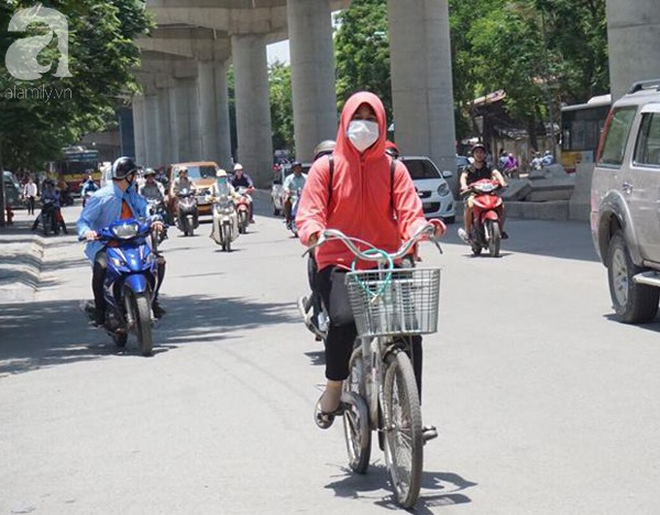 Hà Nội trải qua ngày nắng nóng gắt nhất từ đầu mùa, người dân bịt kín mít khi ra đường - Ảnh 9.