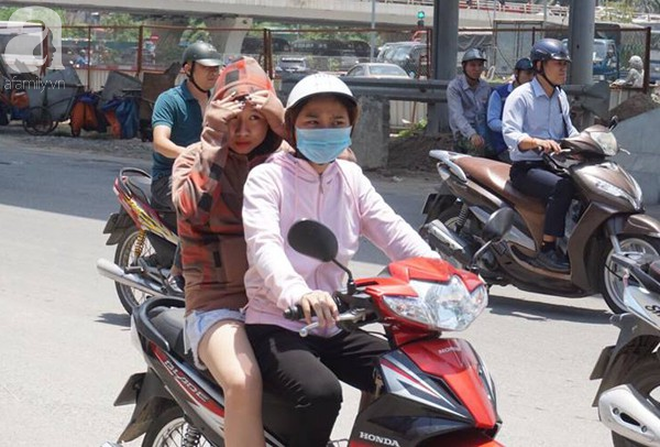 Hà Nội trải qua ngày nắng nóng gắt nhất từ đầu mùa, người dân bịt kín mít khi ra đường - Ảnh 10.