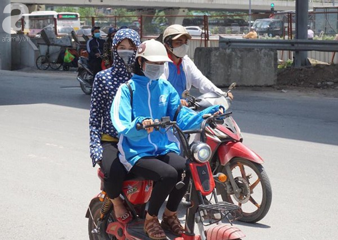 Hà Nội trải qua ngày nắng nóng gắt nhất từ đầu mùa, người dân bịt kín mít khi ra đường - Ảnh 4.