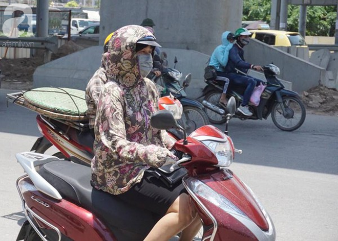 Hà Nội trải qua ngày nắng nóng gắt nhất từ đầu mùa, người dân bịt kín mít khi ra đường - Ảnh 7.