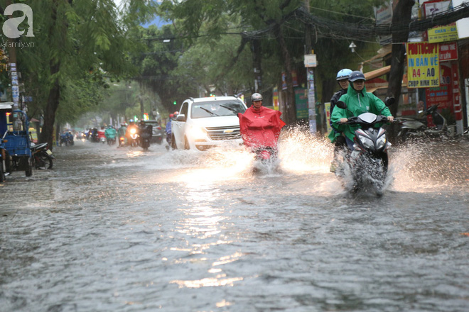 Sài Gòn sau cơn mưa khủng, bố mẹ bì bõm lội nước bế con đi học về - Ảnh 1.