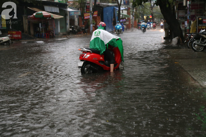 Sài Gòn sau cơn mưa khủng, bố mẹ bì bõm lội nước bế con đi học về - Ảnh 14.