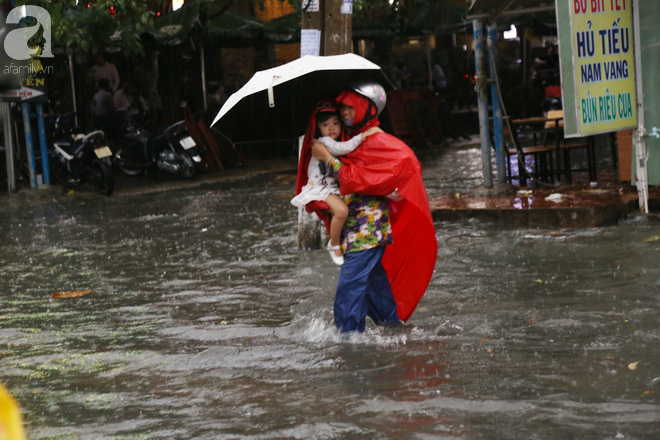 Sài Gòn sau cơn mưa khủng, bố mẹ bì bõm lội nước bế con đi học về - Ảnh 4.