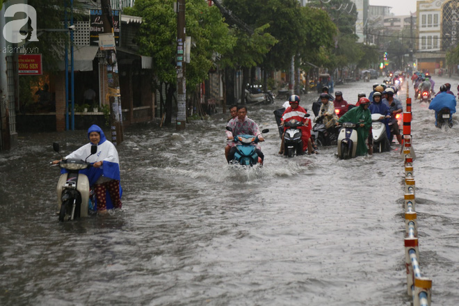 Sài Gòn sau cơn mưa khủng, bố mẹ bì bõm lội nước bế con đi học về - Ảnh 2.