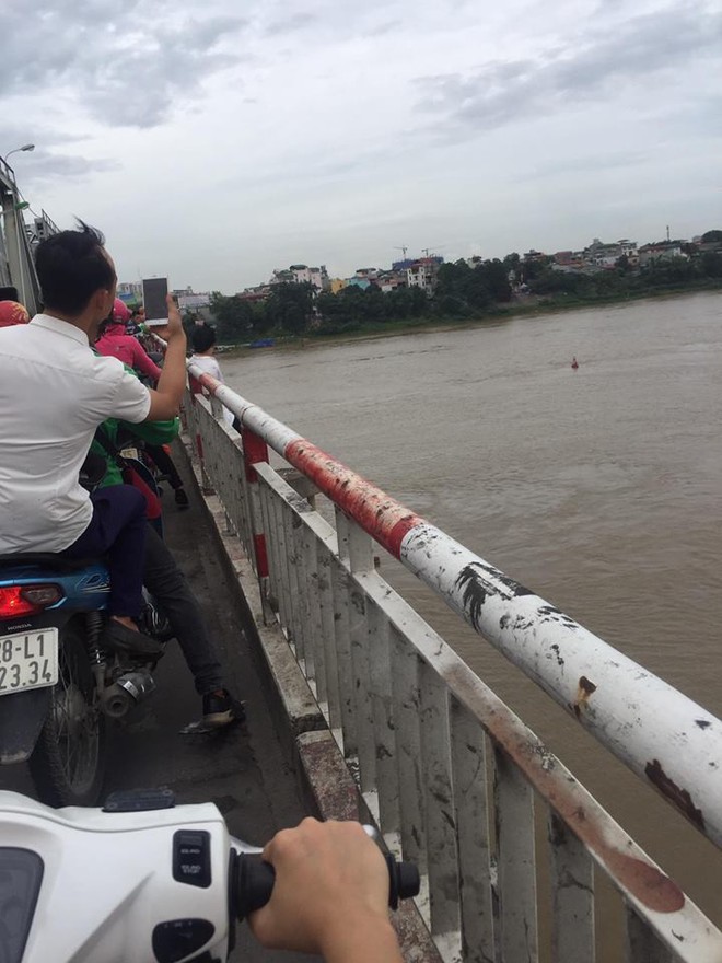 Hà Nội: Người phụ nữ trung tuổi trèo qua thành cầu Chương Dương khiến người dân xúm lại xem, giao thông ùn tắc - Ảnh 2.