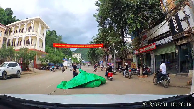 Clip: Xe tải đang đi thì bạt che sau bất ngờ bay xuống trùm kín xe máy, khiến nam thanh niên ngã sõng soài - Ảnh 4. Clip: Xe tải đang đi thì bạt che sau bất ngờ bay xuống trùm kín xe máy, khiến nam thanh niên ngã sõng soài - Ảnh 4.