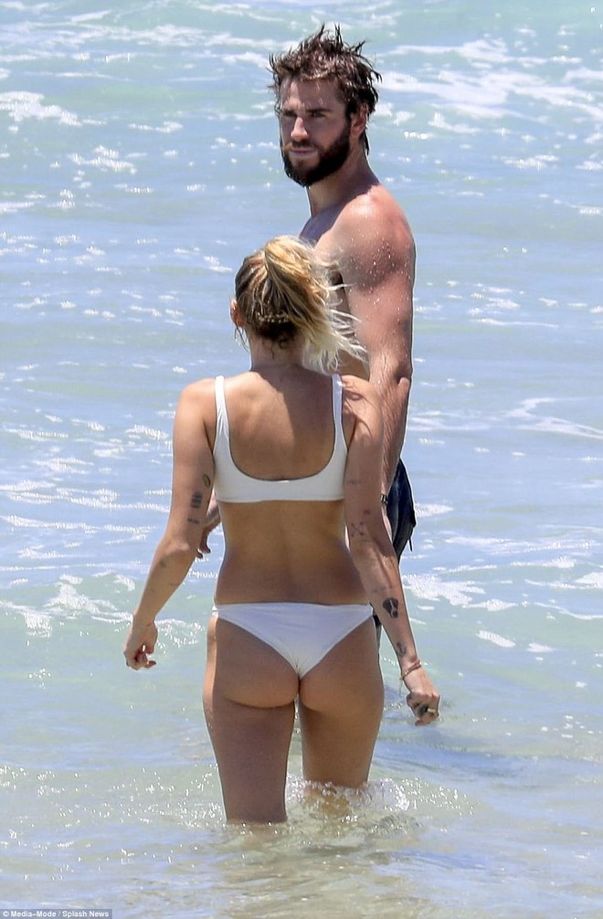 Miley Cyrus diện bikini nóng bỏng, nô đùa trên biển với bạn trai Liam Hemsworth - Ảnh 2.